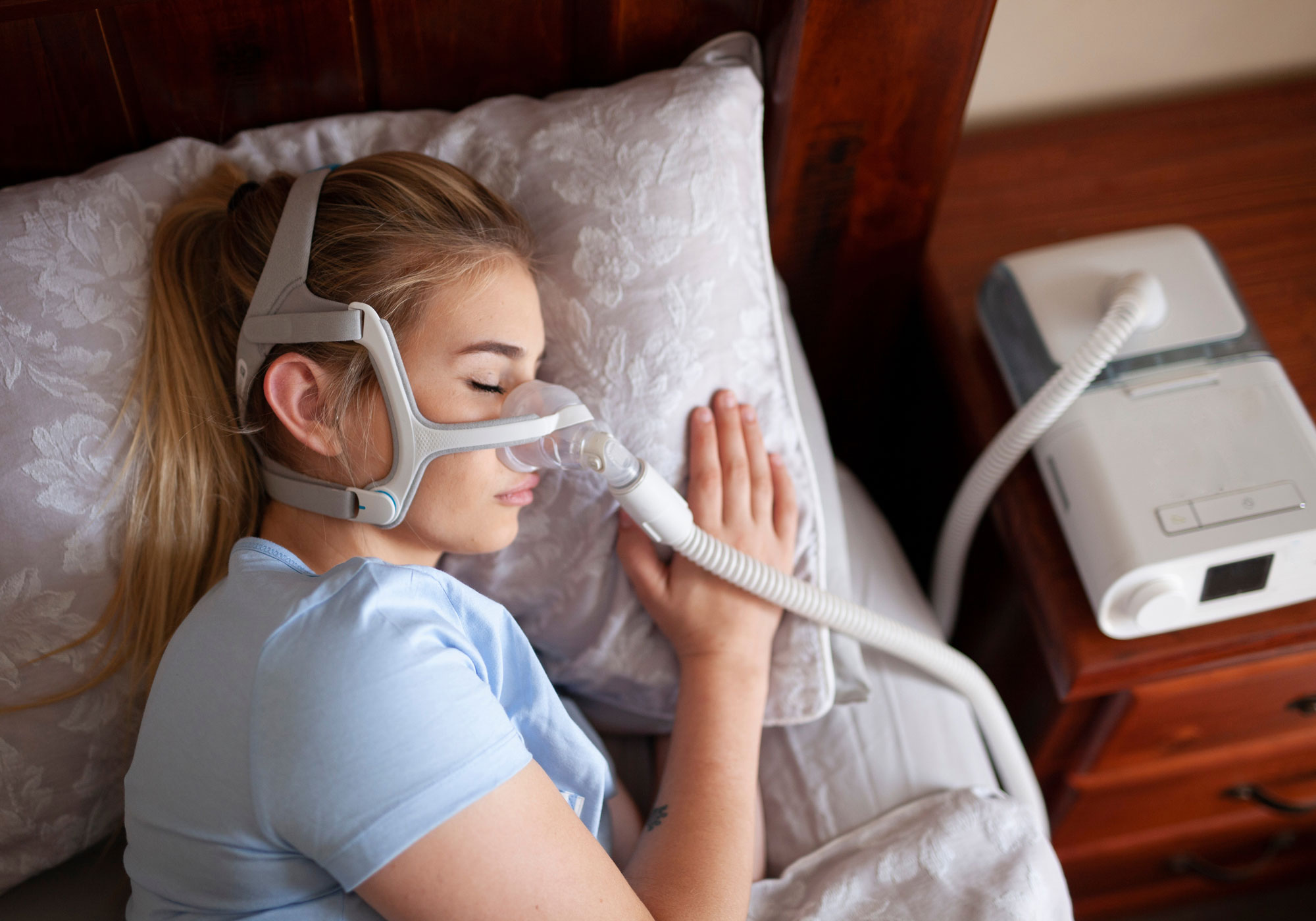 female laying in bed with cpap machine on